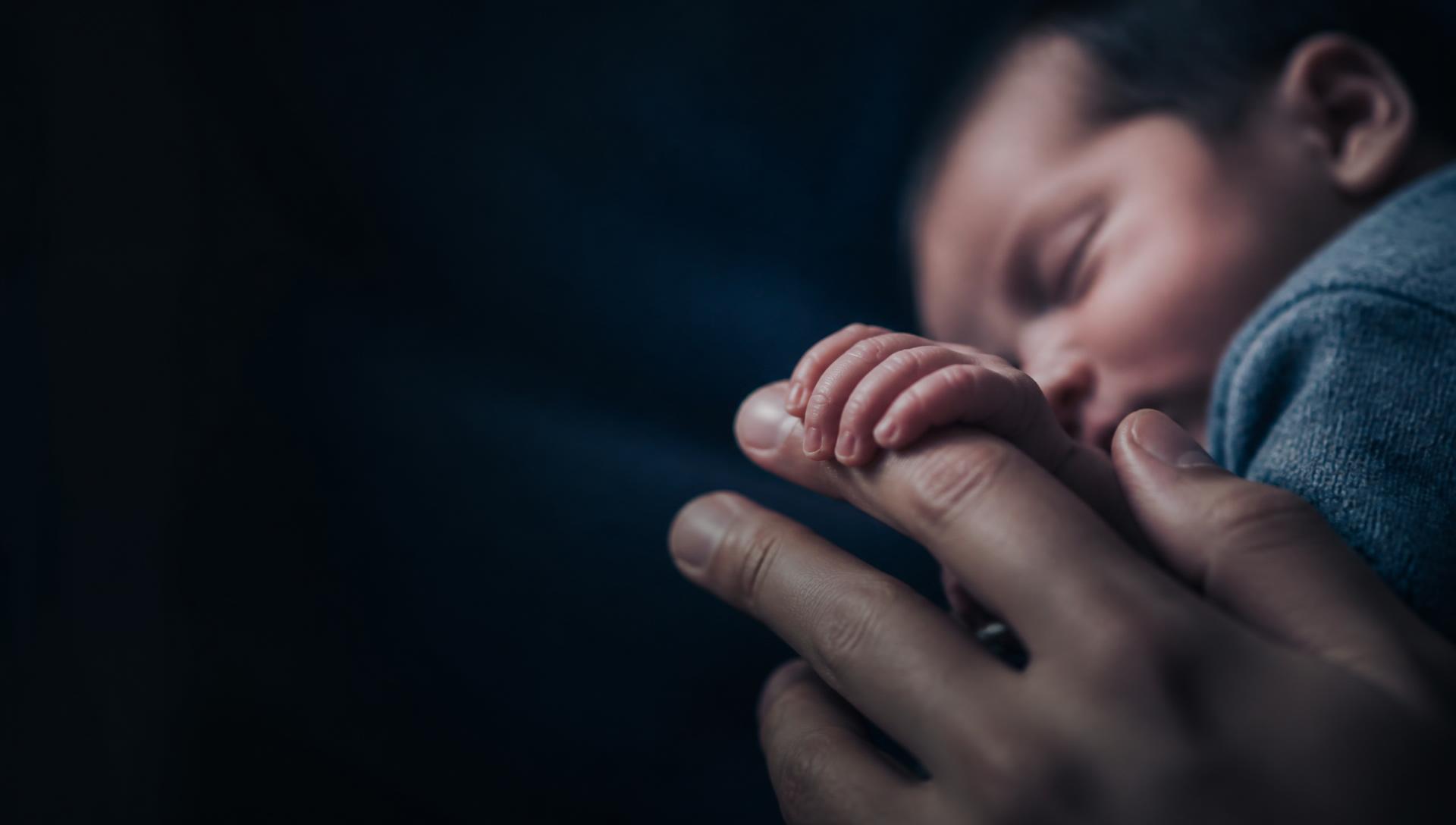 Mão de recém-nascido segurando o dedo da mãe